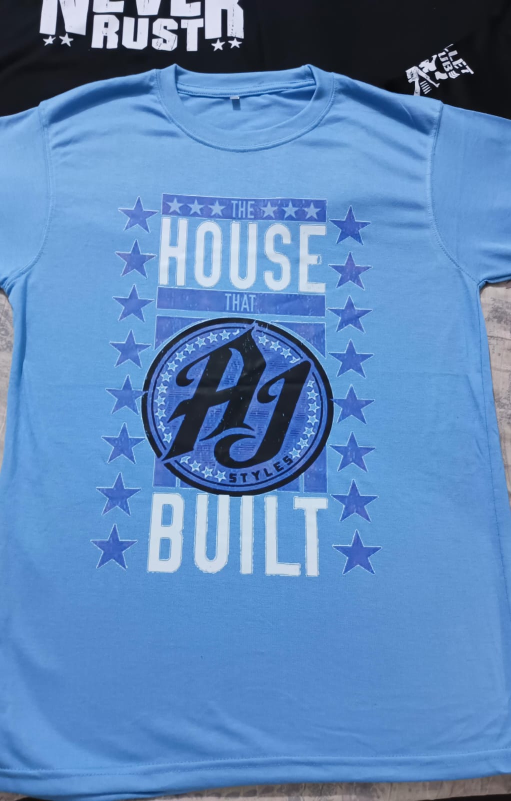 WWE AJ STYLES “THE HOUSE THAT AJ BUILT” T-SHIRT (Light Blue)